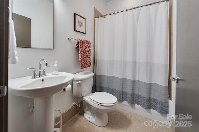 bathroom with tile patterned flooring, toilet, and shower / bath combo with shower curtain