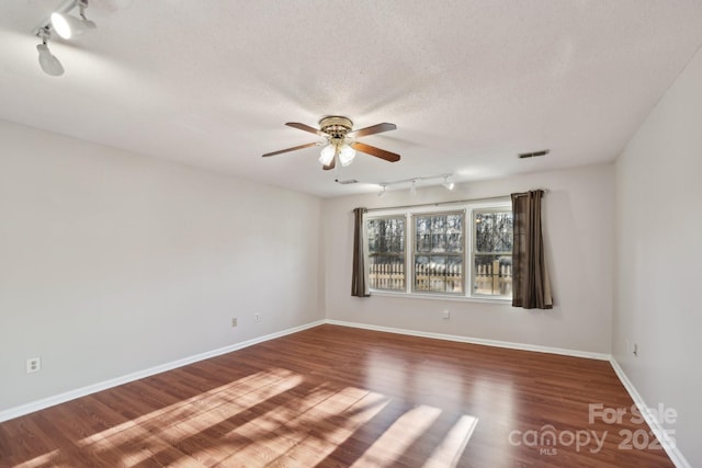 empty room featuring ceiling fan, a textured ceiling, and hardwood / wood-style flooring