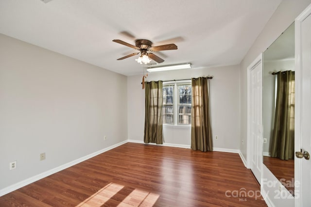 spare room with ceiling fan and dark wood-type flooring