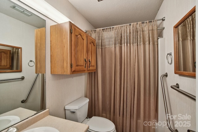 bathroom featuring vanity, a textured ceiling, and toilet