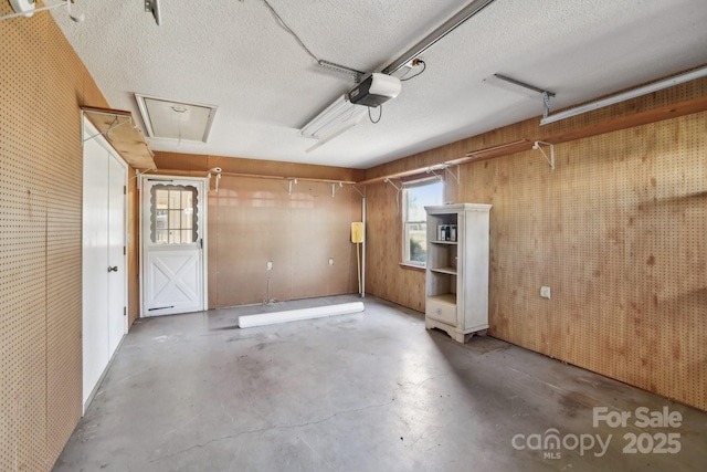 garage featuring wooden walls and a garage door opener