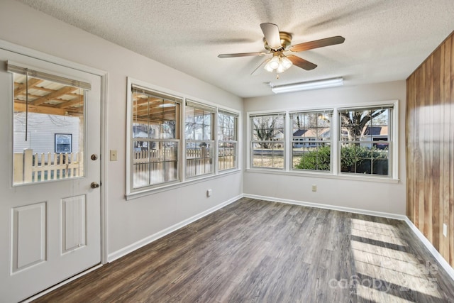 unfurnished sunroom featuring ceiling fan and a healthy amount of sunlight