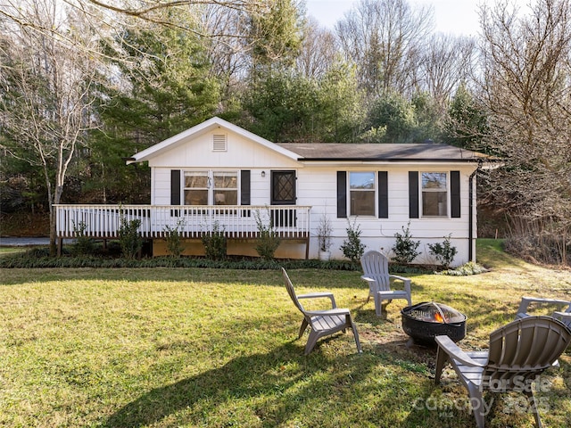 exterior space featuring a yard, a deck, and an outdoor fire pit