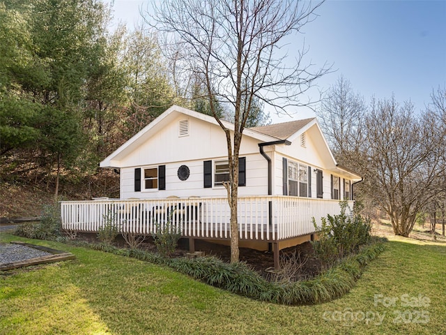 rear view of property featuring a lawn and a wooden deck