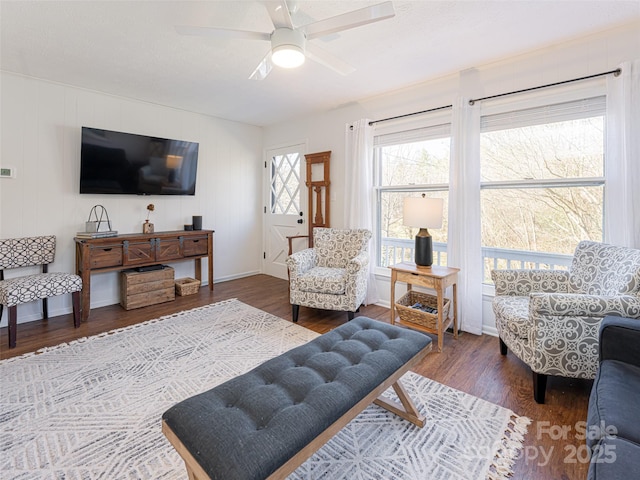 living room featuring ceiling fan and dark hardwood / wood-style flooring