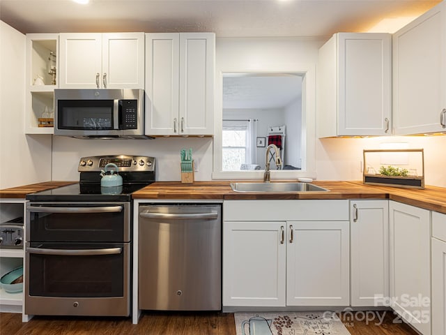 kitchen with wood counters, white cabinetry, sink, and appliances with stainless steel finishes