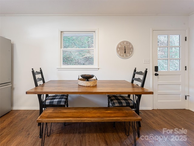 dining space featuring crown molding, plenty of natural light, and dark hardwood / wood-style floors