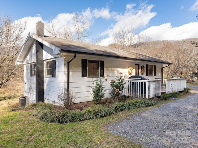 view of side of home with central AC and a deck