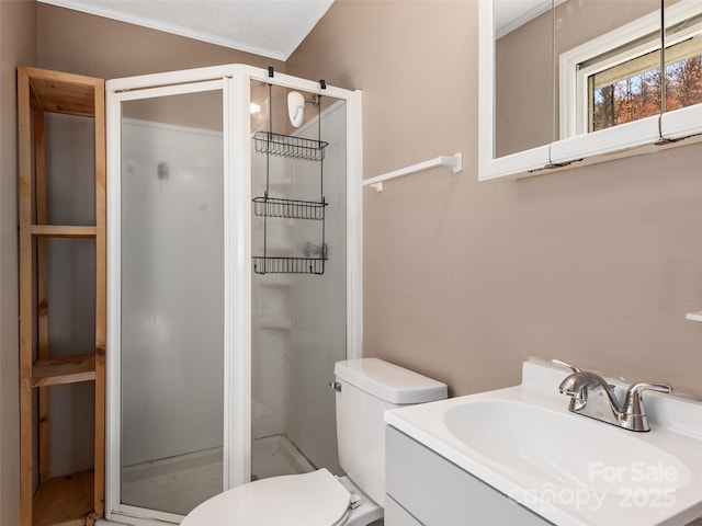 bathroom featuring an enclosed shower, vanity, toilet, and crown molding