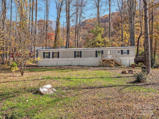 manufactured / mobile home featuring a front yard and a wooden deck