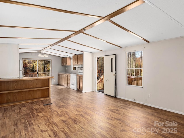 unfurnished living room with hardwood / wood-style floors and vaulted ceiling