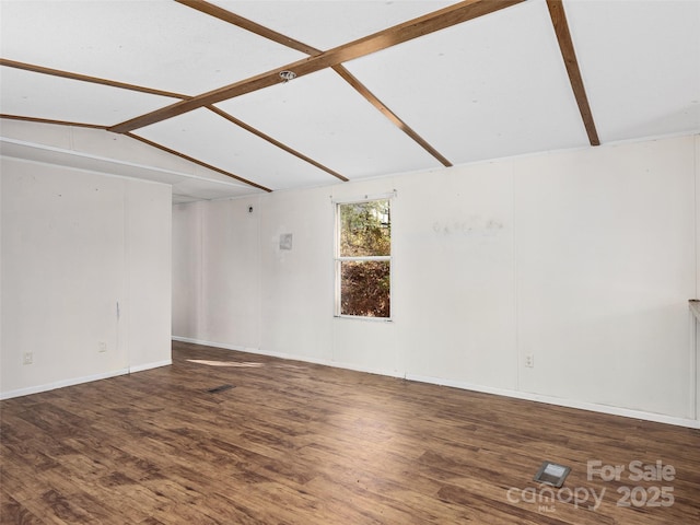 spare room featuring hardwood / wood-style floors and vaulted ceiling