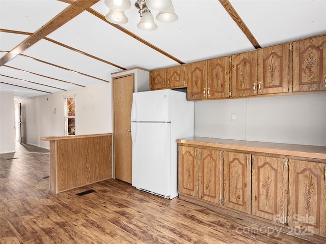 kitchen with hardwood / wood-style flooring, white fridge, and an inviting chandelier