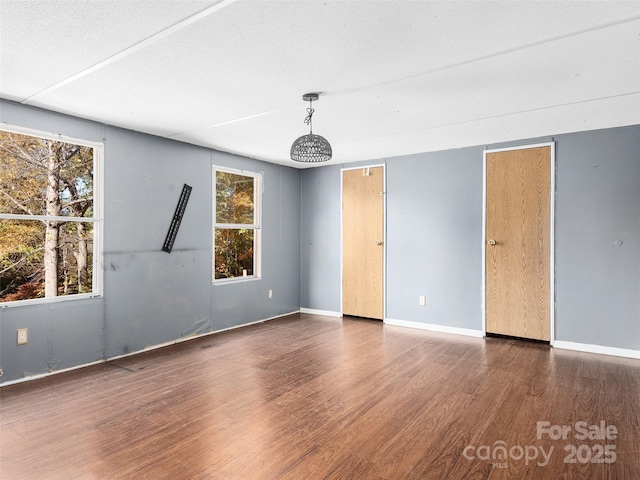 spare room with dark wood-type flooring and a textured ceiling