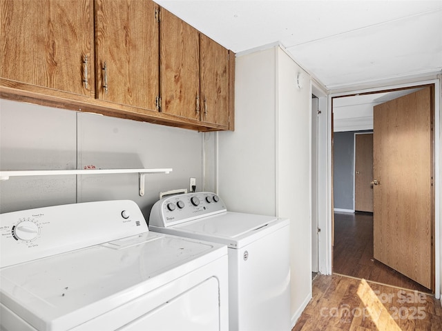 clothes washing area with cabinets, independent washer and dryer, and dark wood-type flooring