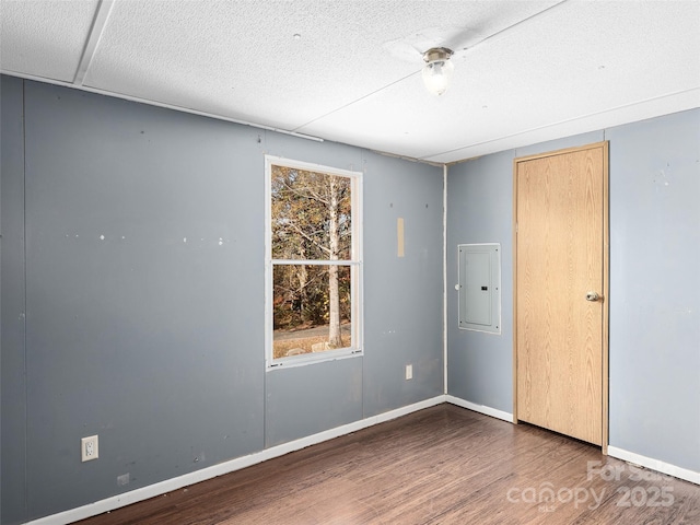 spare room featuring dark wood-type flooring and electric panel