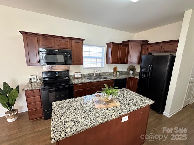 kitchen with black appliances, a kitchen island, dark hardwood / wood-style flooring, and sink