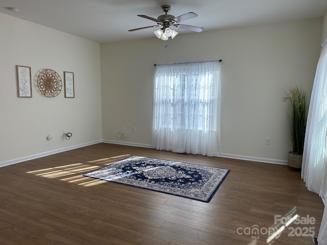 empty room with ceiling fan and dark hardwood / wood-style floors