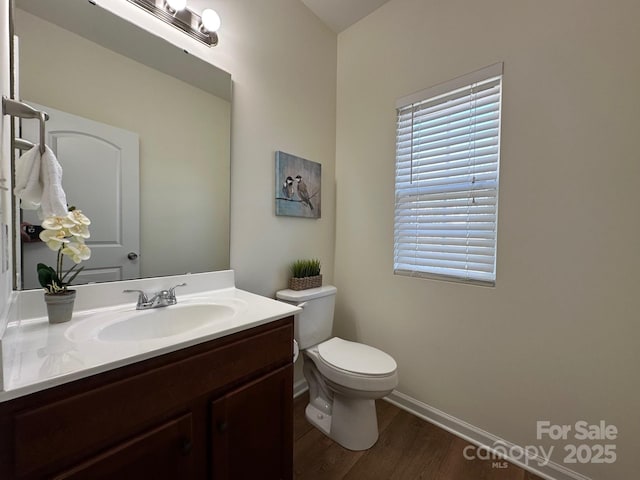 bathroom featuring vanity, hardwood / wood-style flooring, and toilet