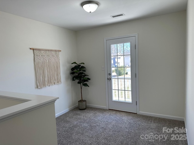 doorway with dark colored carpet