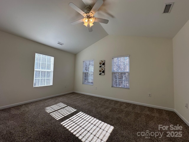 carpeted empty room with plenty of natural light, ceiling fan, and vaulted ceiling