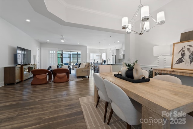 dining room with ceiling fan with notable chandelier, crown molding, and dark hardwood / wood-style floors