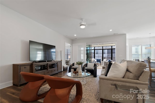 living room with ceiling fan and dark hardwood / wood-style flooring