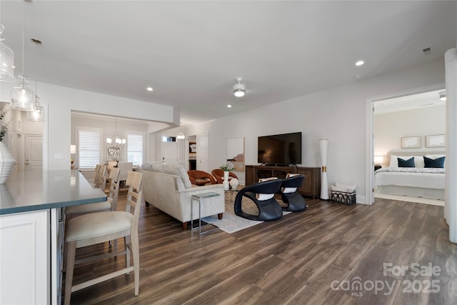 living room with a notable chandelier and dark wood-type flooring