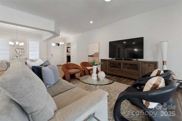 living room featuring crown molding, a chandelier, and wood-type flooring