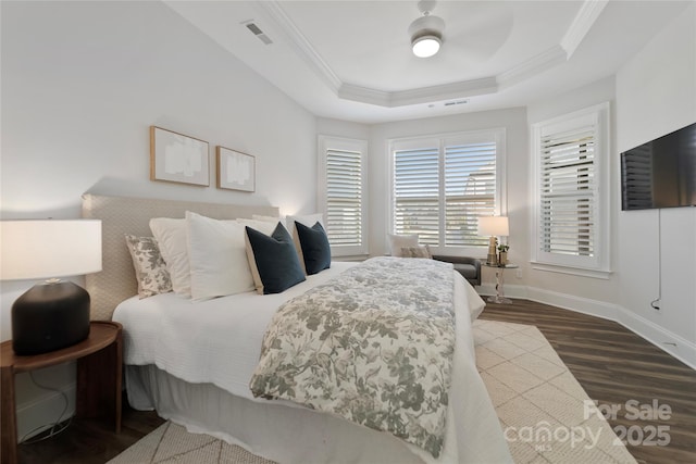 bedroom featuring hardwood / wood-style flooring, ceiling fan, a tray ceiling, and crown molding