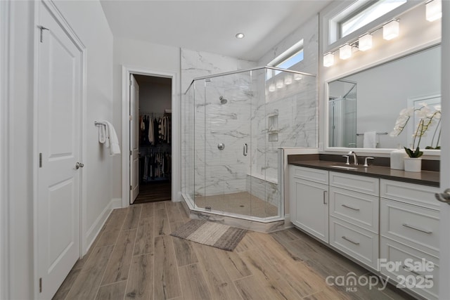 bathroom with a shower with door and vanity