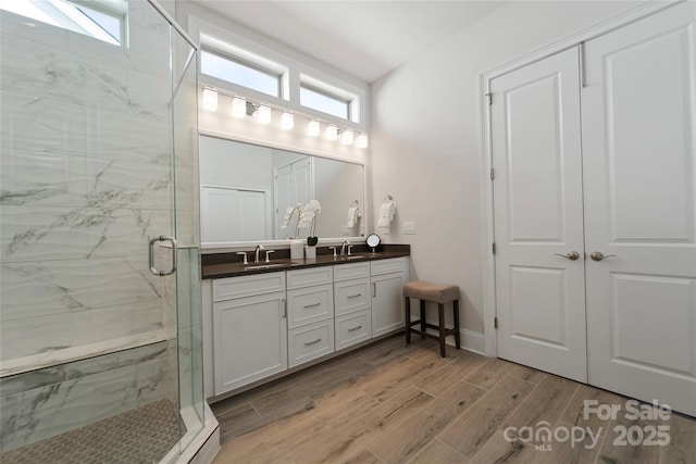 bathroom with a shower with door and vanity