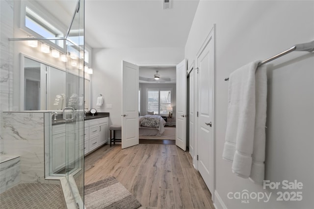 bathroom featuring a shower with door, hardwood / wood-style floors, and vanity