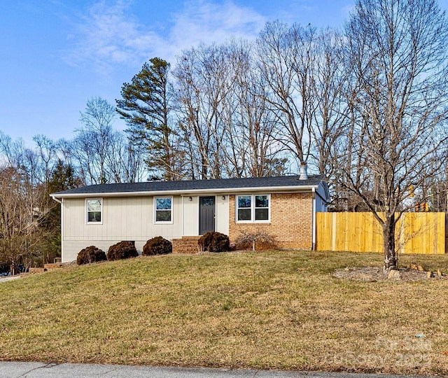 ranch-style home with fence, brick siding, and a front yard