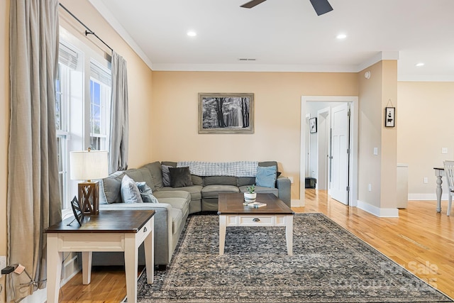 living room featuring ceiling fan, wood-type flooring, and ornamental molding