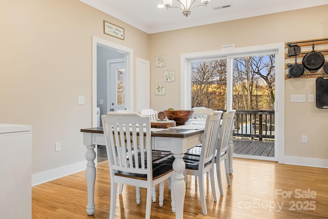 dining room with light hardwood / wood-style flooring and a chandelier