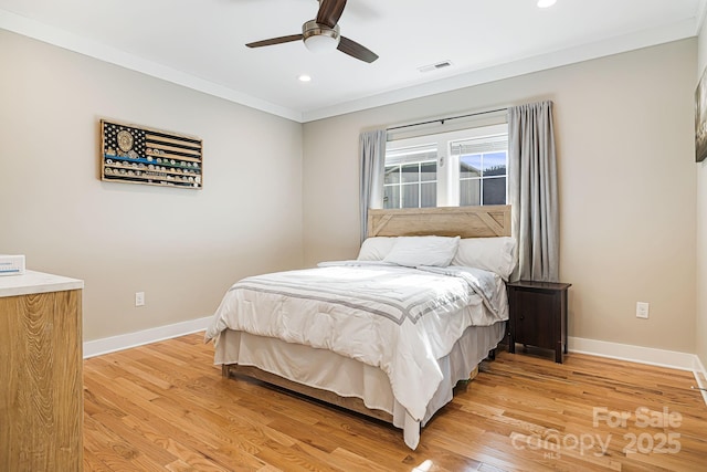 bedroom featuring light hardwood / wood-style floors, ceiling fan, and crown molding