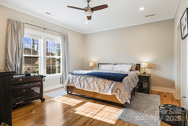 bedroom with light hardwood / wood-style flooring, ceiling fan, and ornamental molding