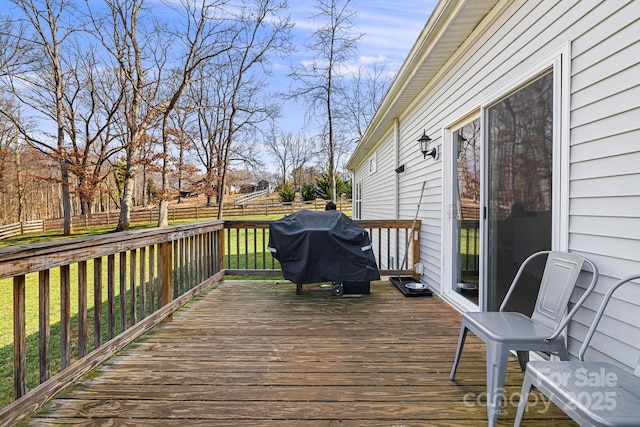 wooden terrace featuring a lawn and area for grilling