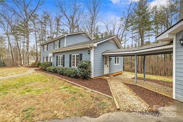 view of home's exterior featuring a carport, a yard, and a chimney