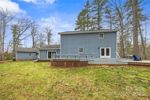 back of house with french doors, a lawn, and a wooden deck