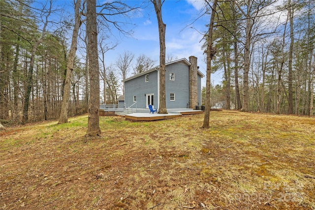 rear view of property with a deck and a chimney