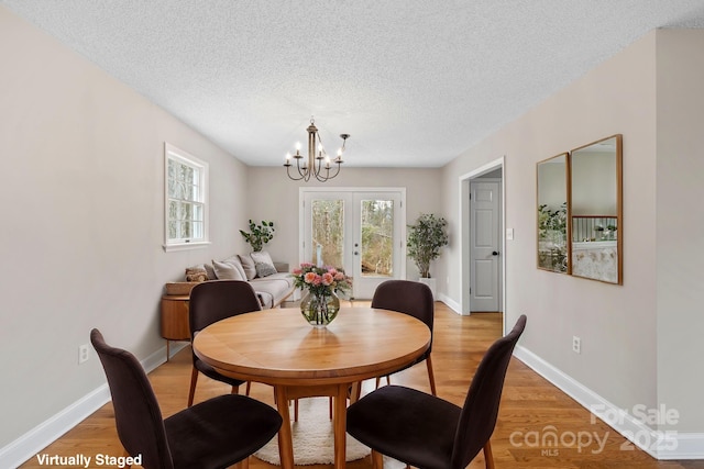 dining room with a wealth of natural light, light wood-style floors, and a chandelier