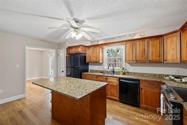 kitchen featuring a sink, brown cabinets, and black appliances