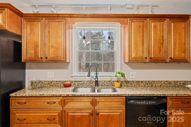 kitchen featuring brown cabinetry, plenty of natural light, black appliances, and a sink