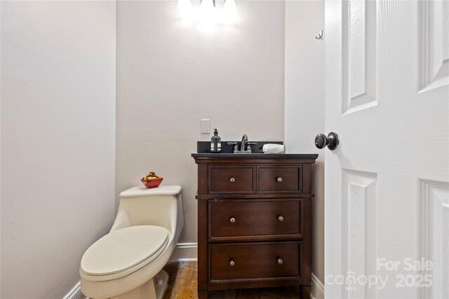 bathroom featuring vanity, toilet, and baseboards