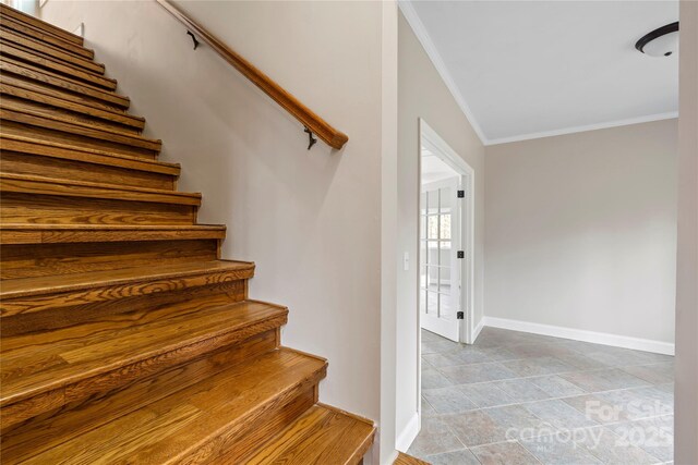 stairs with crown molding and baseboards