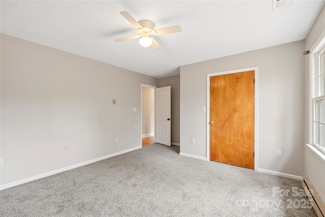 unfurnished bedroom featuring a baseboard radiator, baseboards, a textured ceiling, and carpet flooring