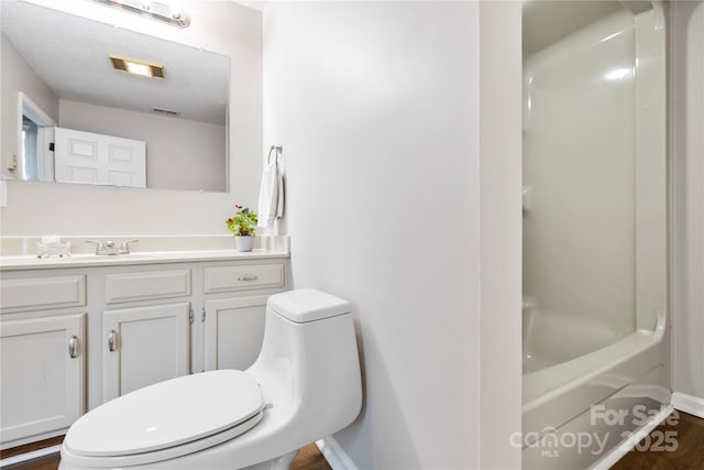 bathroom featuring vanity, toilet, wood finished floors, and visible vents