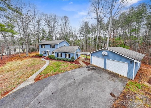 view of front of house featuring an outdoor structure, a garage, and a front yard